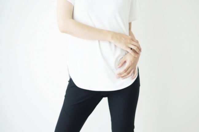 黒パンツと白いTシャツを着た立ち姿の女性